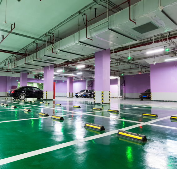 This image shows a commercial parking area that has a green epoxy color and white lines.
