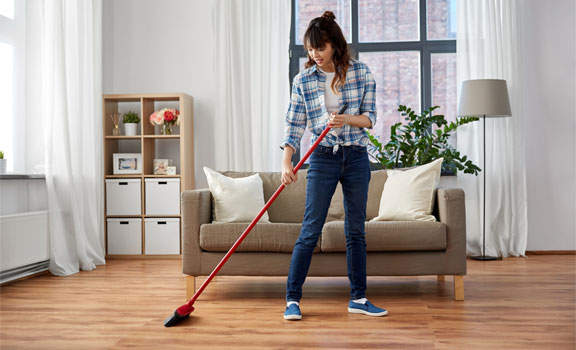 This image shows a woman sweeping the floor.