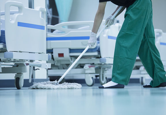 This image shows a man mopping the floor at a hospital.