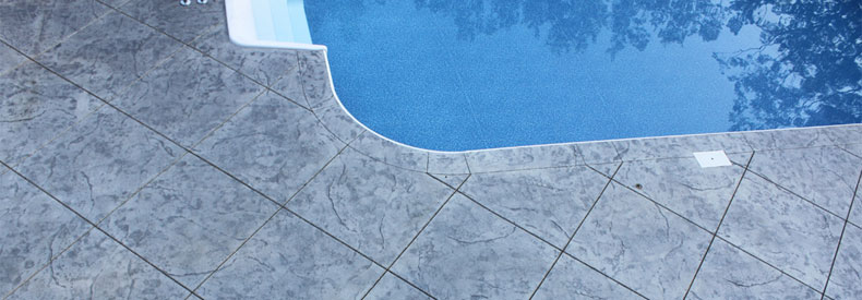This image shows a pool deck with stamped concrete.
