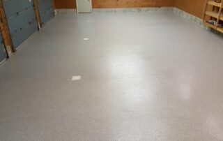 This image shows a garage floor with flake epoxy painted floor.